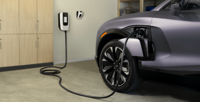 Purple Chevrolet electric SUV charging from a wall-mounted unit in a home garage