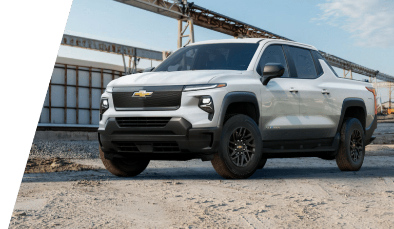 White Chevrolet Silverado EV work truck parked at an industrial site