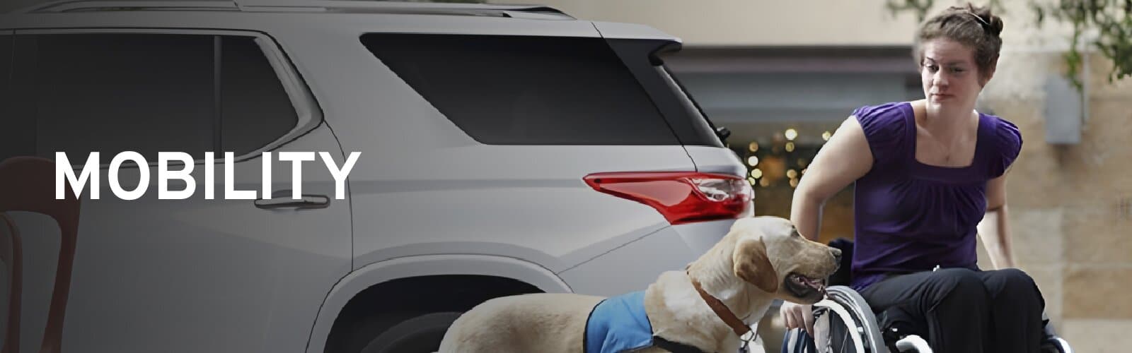 Woman in a wheelchair with a service dog beside a silver Chevrolet SUV, under the word Mobility