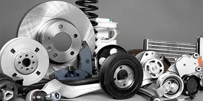 Assortment of genuine auto parts including brake rotors, pulleys, suspension arms and a radiator