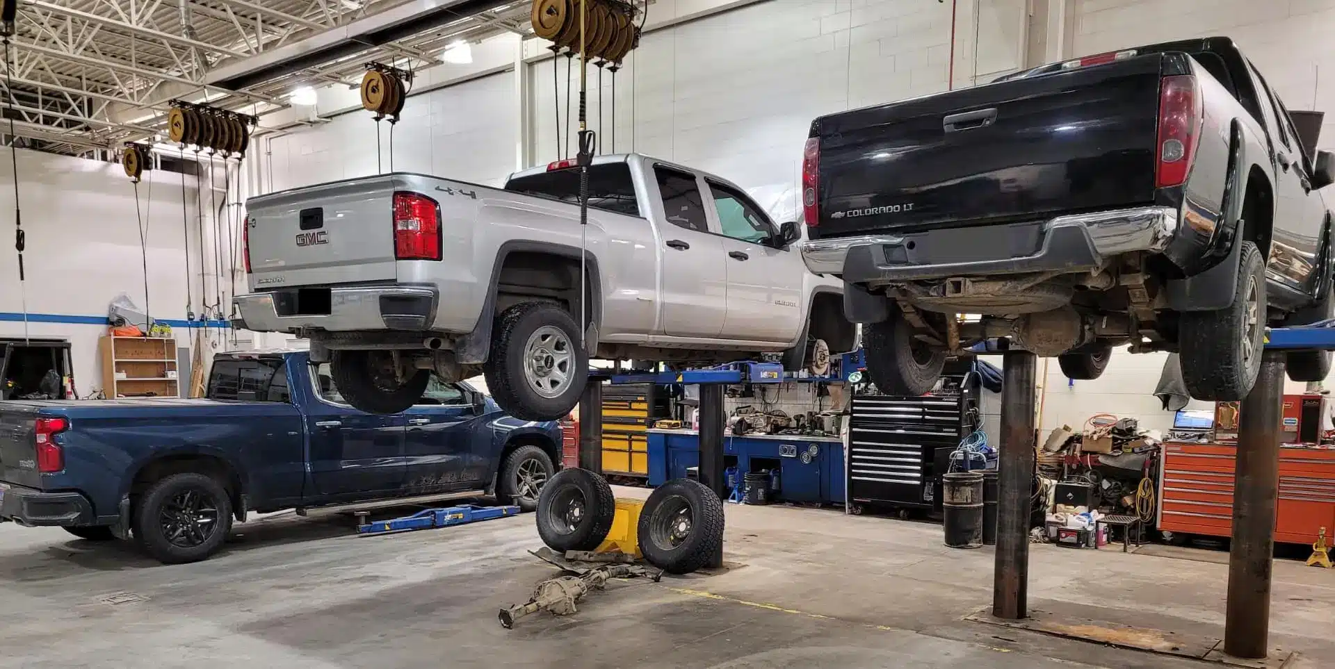 GMC Sierra and Chevrolet Colorado pickups raised on hoists in the Wood Wheaton Supercentre service shop
